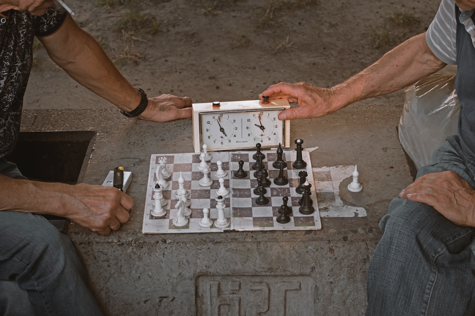 person playing chess on gray concrete floor