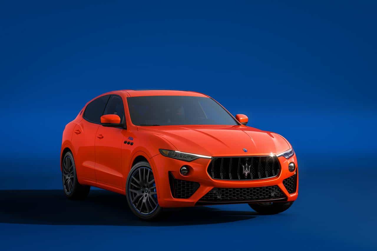 Orangefarbener Maserati Levante SUV in Dreiviertel-Frontansicht vor einheitlich blauem Hintergrund