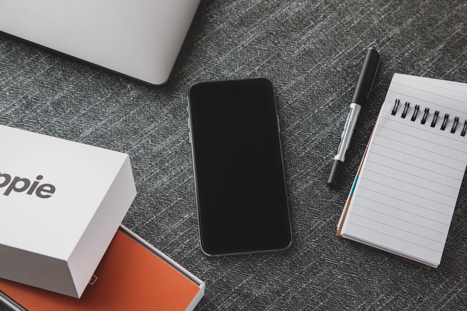 black ipad beside black pen